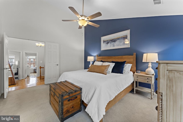 bedroom featuring visible vents, carpet, high vaulted ceiling, and ceiling fan with notable chandelier