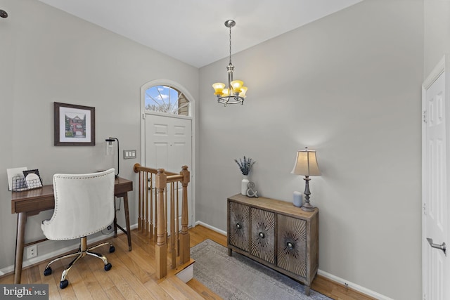 office space featuring a notable chandelier, baseboards, and light wood finished floors