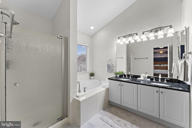 bathroom featuring a shower stall, a garden tub, lofted ceiling, and a sink