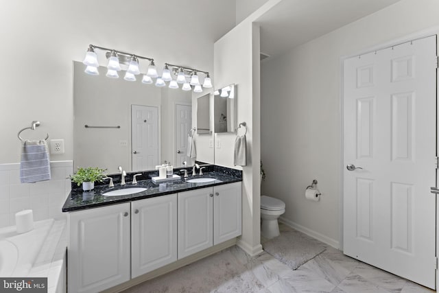 bathroom featuring double vanity, toilet, marble finish floor, and a sink