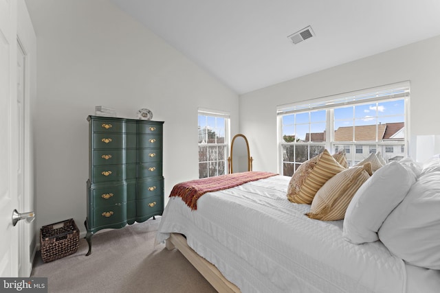 carpeted bedroom featuring visible vents and vaulted ceiling