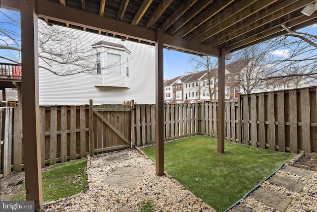 view of yard featuring a residential view, a fenced backyard, and a gate