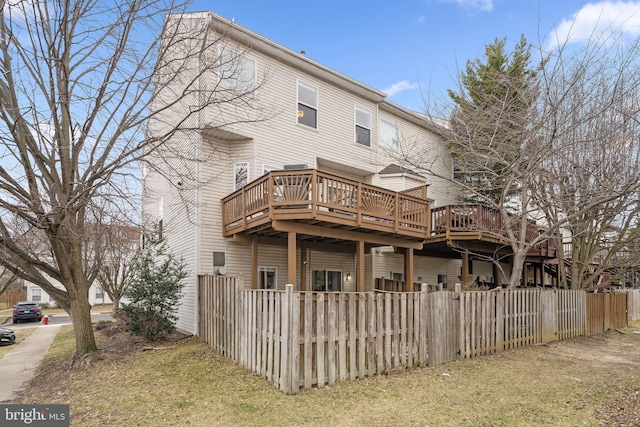 back of house featuring a deck and fence