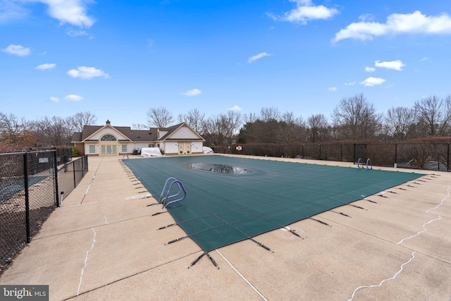 pool with a patio area and fence