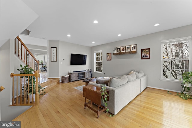 living room featuring recessed lighting, baseboards, hardwood / wood-style floors, and stairs