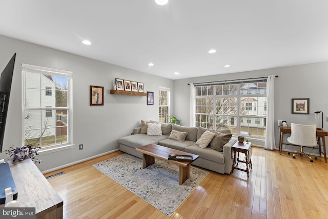 living area with recessed lighting, visible vents, baseboards, and light wood-style flooring