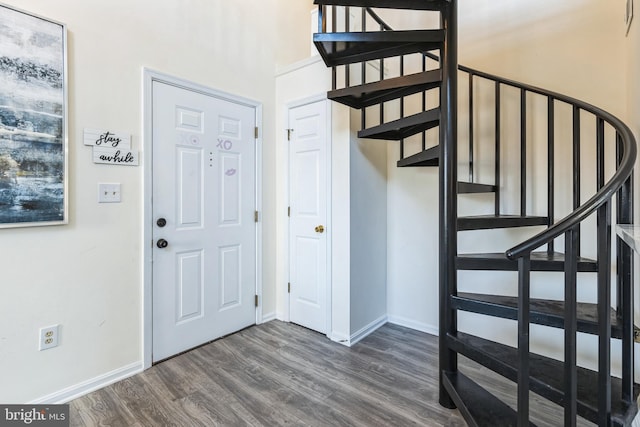 foyer entrance featuring stairs, dark wood-style flooring, and baseboards