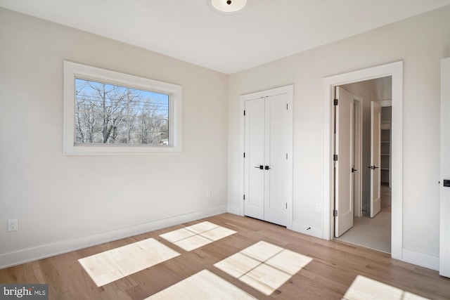 unfurnished bedroom featuring a closet and light wood-type flooring