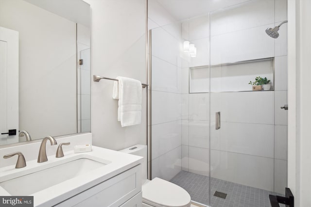 bathroom featuring vanity, toilet, and a shower with door