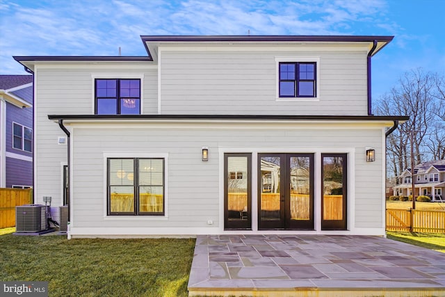 rear view of house featuring cooling unit, a yard, and a patio