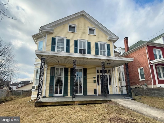 traditional home with fence and a porch