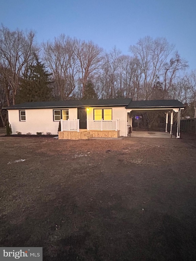 view of front of house featuring stucco siding and a carport