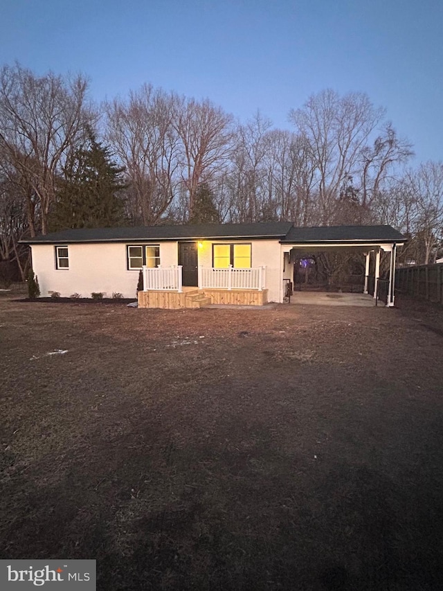 view of front facade featuring stucco siding and a carport