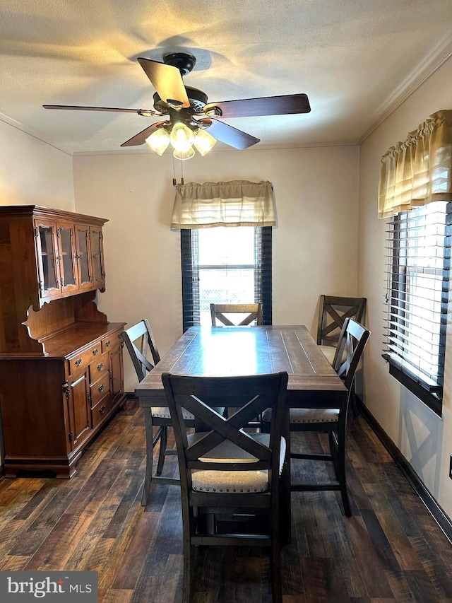 dining area with ceiling fan, dark wood-type flooring, a textured ceiling, and ornamental molding