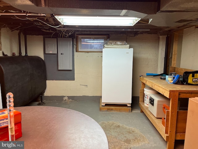 basement featuring white fridge and electric panel