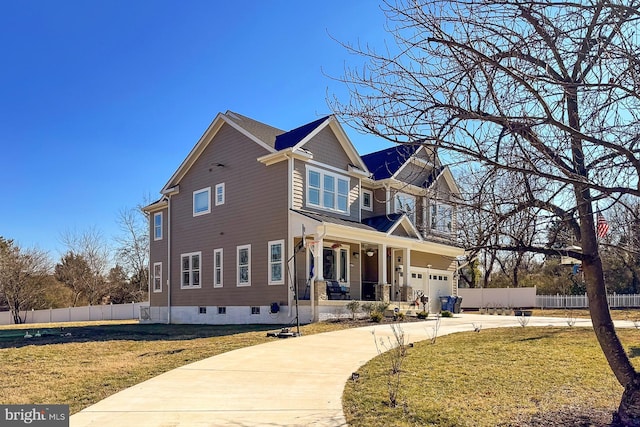 view of front of home featuring a garage, a front lawn, and covered porch