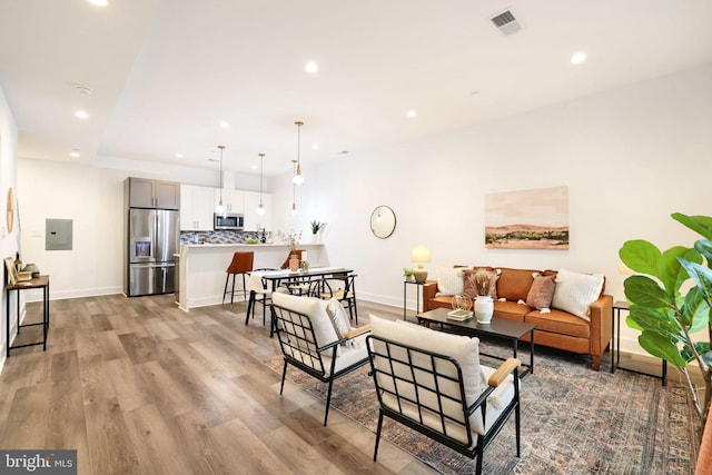 living room with electric panel and light hardwood / wood-style floors