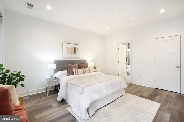 bedroom with wood-type flooring and ensuite bath