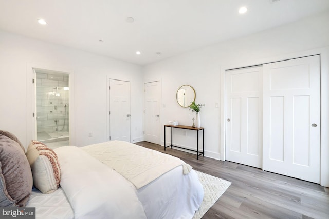 bedroom with a closet, ensuite bathroom, and light hardwood / wood-style flooring