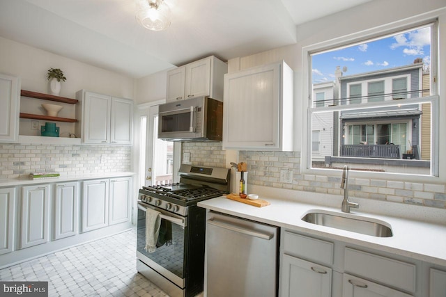 kitchen featuring tasteful backsplash, appliances with stainless steel finishes, sink, and white cabinets