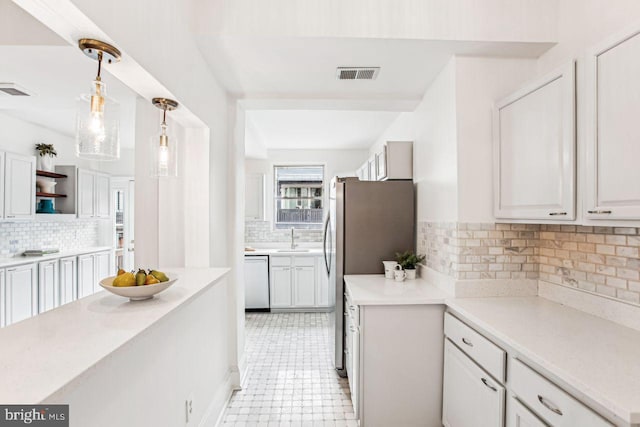 kitchen with hanging light fixtures, white cabinetry, appliances with stainless steel finishes, and sink