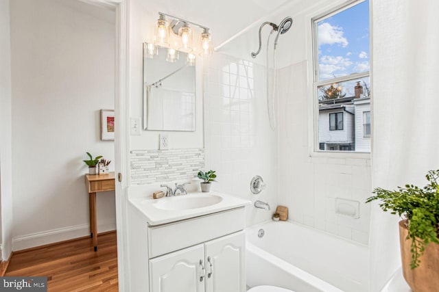 bathroom featuring wood-type flooring, shower / tub combo, vanity, and backsplash