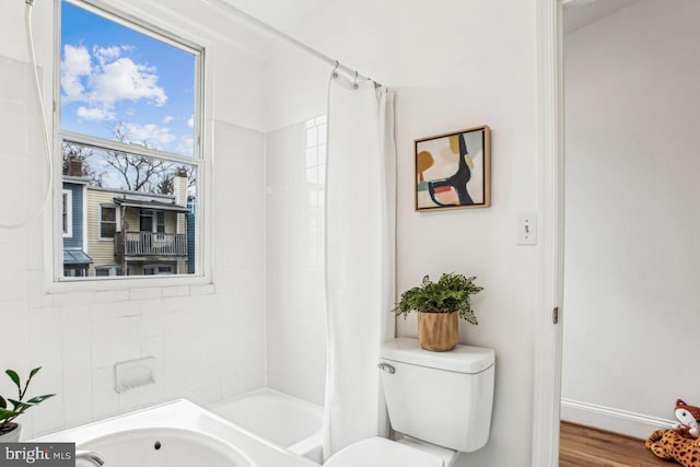 bathroom featuring hardwood / wood-style floors, shower / tub combo, and toilet