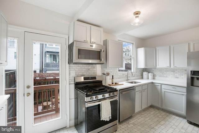 kitchen featuring tasteful backsplash, appliances with stainless steel finishes, sink, and white cabinets