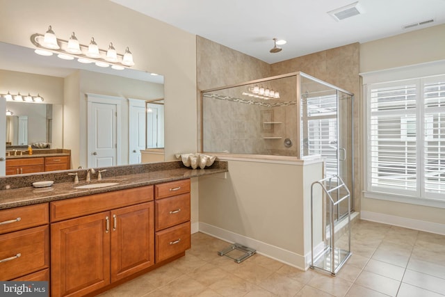 bathroom with tile patterned flooring, vanity, and walk in shower