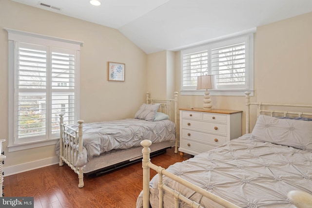 bedroom with multiple windows, vaulted ceiling, and dark hardwood / wood-style floors