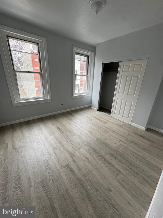 unfurnished bedroom with light hardwood / wood-style flooring and a closet