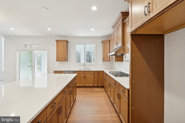 kitchen with sink, a wealth of natural light, stainless steel gas cooktop, and light wood-type flooring