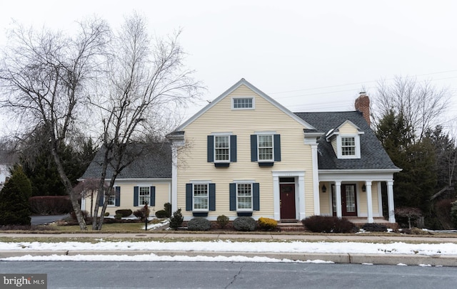 traditional home featuring a shingled roof and a chimney