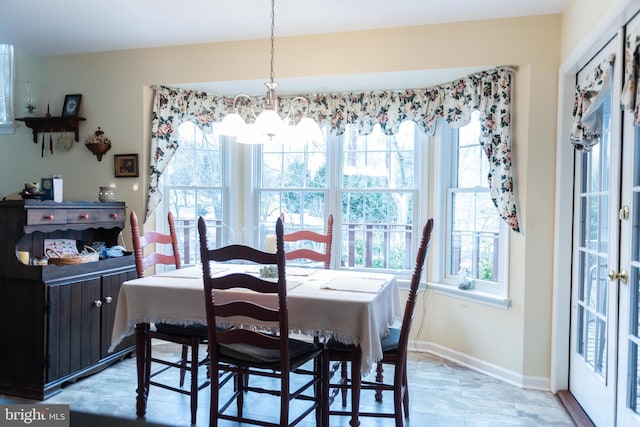 dining area featuring a notable chandelier and baseboards