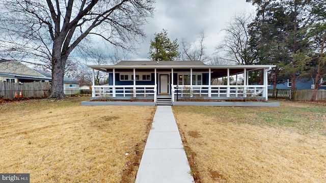 farmhouse featuring a porch, fence, and a front lawn