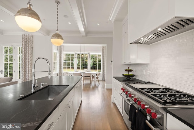 kitchen featuring white cabinets, custom range hood, a sink, double oven range, and backsplash