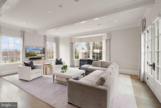 living room with beam ceiling, plenty of natural light, and wood finished floors