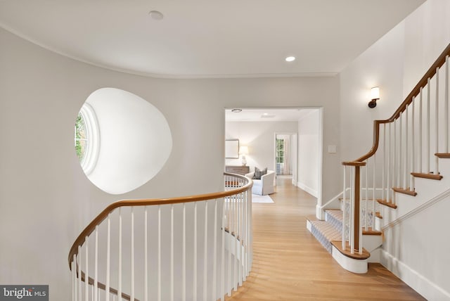 corridor featuring light wood finished floors, recessed lighting, and baseboards