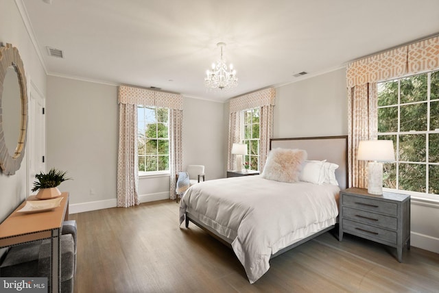 bedroom featuring baseboards, crown molding, visible vents, and wood finished floors