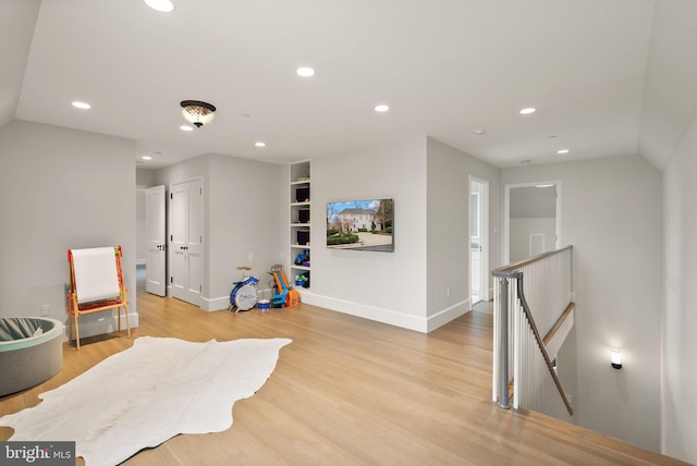 sitting room with light wood finished floors, recessed lighting, and an upstairs landing