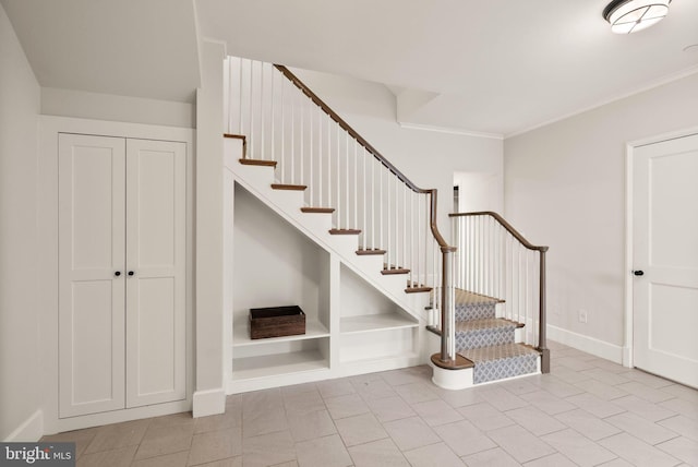 staircase featuring baseboards and ornamental molding