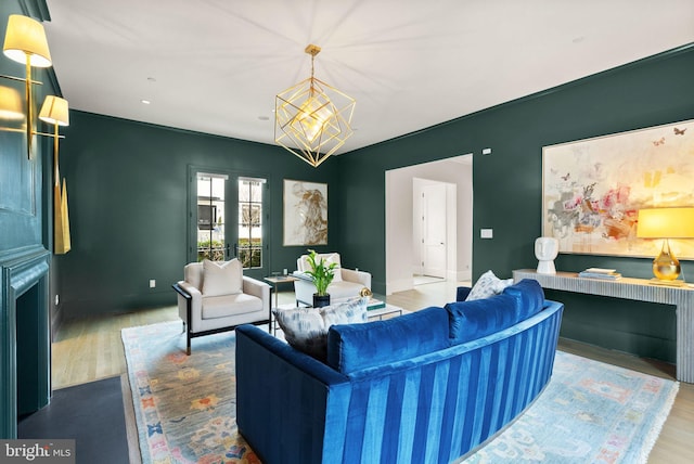 living area featuring baseboards, a chandelier, and wood finished floors