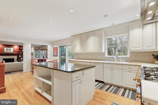 kitchen with plenty of natural light, a kitchen island, and light wood-style flooring