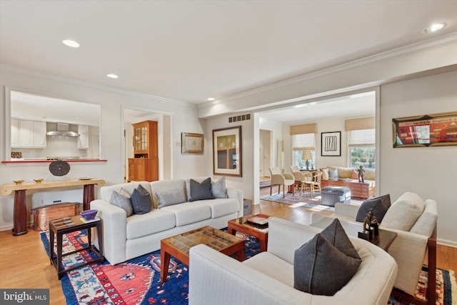 living area featuring recessed lighting, visible vents, ornamental molding, and wood finished floors