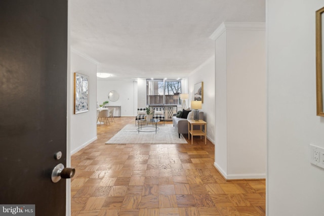 interior space with baseboards and crown molding