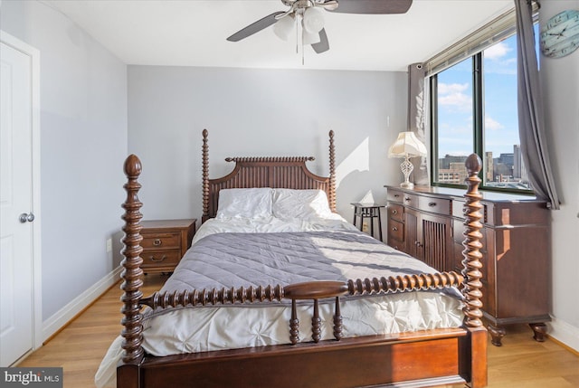 bedroom featuring light wood-type flooring, a ceiling fan, and baseboards