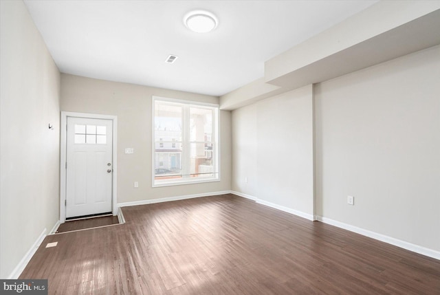 foyer featuring dark wood-style floors, visible vents, and baseboards