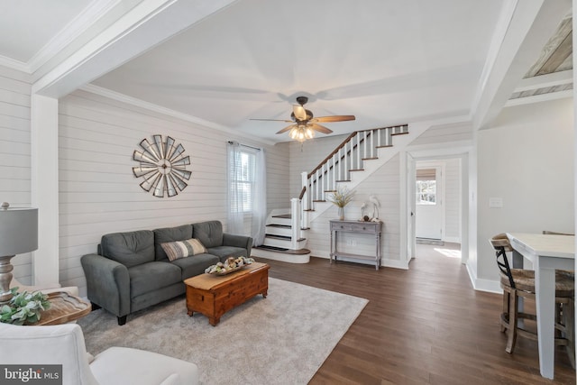 living room featuring dark wood-type flooring, plenty of natural light, ornamental molding, and stairs