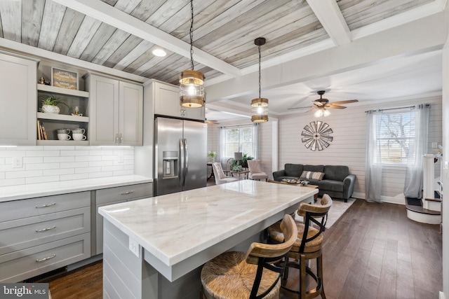 kitchen featuring stainless steel fridge, dark wood finished floors, gray cabinets, and beamed ceiling