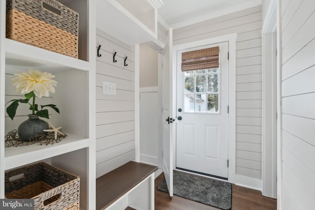 mudroom featuring dark wood finished floors and wood walls